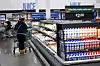 Customer with trolley choosing items in the refrigerated dairy aisle of a Walmart Supercenter.