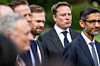 Elon Musk (lijevo) u tamnom odijelu i kravati stoji među muškarcima, uz Sundara Pichaija (desno), na otvorenom.